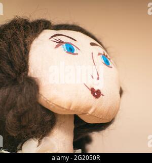 Le visage d'une poupée de chiffon maison avec des yeux bleus. Portrait d'une poupée de chiffon. Mise au point sélective Banque D'Images