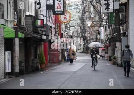 OSAKA, JAPON - 06 décembre 2019 : Osaka, Japon - 02 décembre 2019 : personnes avec parasols dans la rue humide en journée de pluie à Osaka, Japon. Banque D'Images