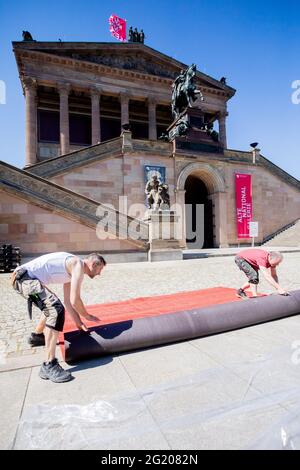 Berlin, Allemagne. 07e juin 2021. Les techniciens de l'événement martelent dans un morceau de tapis rouge pour la Berlinale sur l'île des musées, devant l'Alte Nationalgalerie, pour la porter un peu plus loin sur le site d'installation. L'offre spéciale d'été de la Berlinale sera ouverte par cérémonie sur l'île Museum le 9 juin 2021. Le 13 juin 2021 aura lieu la cérémonie de remise des prix déjà décidée par les jurys officiels en mars 2021. Credit: Christoph Soeder/dpa Pool/dpa/Alay Live News Banque D'Images