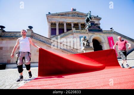 Berlin, Allemagne. 07e juin 2021. Les techniciens de l'événement martelent dans un morceau de tapis rouge pour la Berlinale sur l'île des musées, devant l'Alte Nationalgalerie, pour la porter un peu plus loin sur le site d'installation. L'offre spéciale d'été de la Berlinale sera ouverte par cérémonie sur l'île Museum le 9 juin 2021. Le 13 juin 2021 aura lieu la cérémonie de remise des prix déjà décidée par les jurys officiels en mars 2021. Credit: Christoph Soeder/dpa Pool/dpa/Alay Live News Banque D'Images