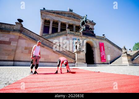 Berlin, Allemagne. 07e juin 2021. Les techniciens de l'événement posent le tapis rouge de la Berlinale sur l'île des musées. L'offre spéciale d'été de la Berlinale sera ouverte par cérémonie sur l'île Museum le 9 juin 2021. La cérémonie de remise des prix déjà décidée par les jurys officiels en mars 2021 aura lieu le 13 juin 2021. Credit: Christoph Soeder/dpa Pool/dpa/Alay Live News Banque D'Images