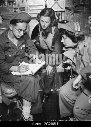 WASP Jeanne d'Ambly (au centre) vérifie les documents de vol avec son ingénieur, le Cpl George J Brown et son opérateur radio, le Cpl Helen Mehegan, avant de prendre un Martin B-26 aloft à Harlingen AAF, Harlingen, TX, vers 1944. (Photo de la US Army Air Force/RBM Vintage Images) Banque D'Images