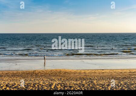 Les surfeurs s'entraînent dans l'océan avec leur entraîneur sur la plage, Faro, Algarve, Portugal Banque D'Images