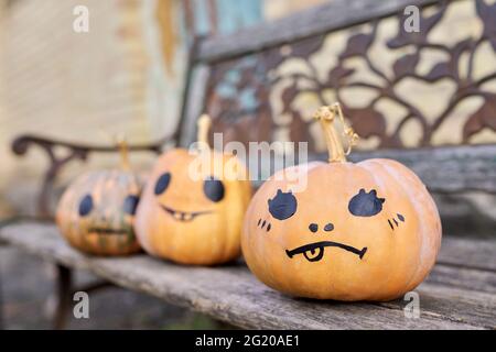 Halloween trois citrouilles en plein air, personne, sur un vieux banc en bois Banque D'Images
