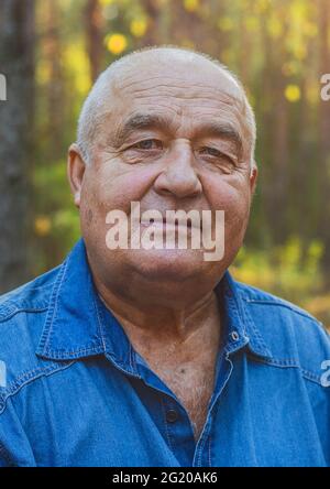 Portrait d'un homme âgé souriant dans un parc à l'extérieur, vie heureuse vécue. Banque D'Images