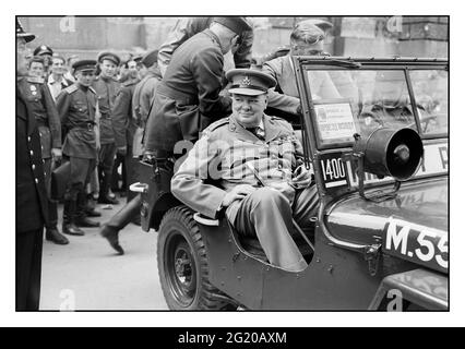 Winston Churchill à Berlin, juillet 1945, le premier ministre Winston Churchill est assis dans une jeep à l'extérieur du Reichstag avec des officiers russes derrière lui, lors d'une visite de la ville ruinée de Berlin, en Allemagne, le 16 juillet 1945 Banque D'Images