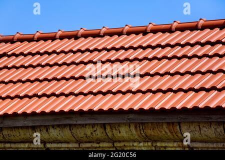 matériau de toiture en carreaux de céramique orange couvrant le toit de la maison, gros plan de la structure d'étanchéité extérieure. Banque D'Images