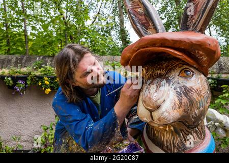 L'artiste Chris Rutterford peint une sculpture humoristique de lièvre en fibre de verre géant dans son studio de plein air pour un parcours artistique caritatif, en Écosse, au Royaume-Uni Banque D'Images