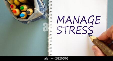 Gérer le symbole de contrainte. Médecin écrivant les mots concept 'gérer stress' sur note blanche, isolé sur fond bleu. Groupe de crayons branche d'arbre stylisée i Banque D'Images