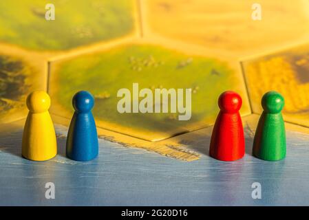 Quatre jetons de couleur différente sur un plateau de jeu jaune Banque D'Images