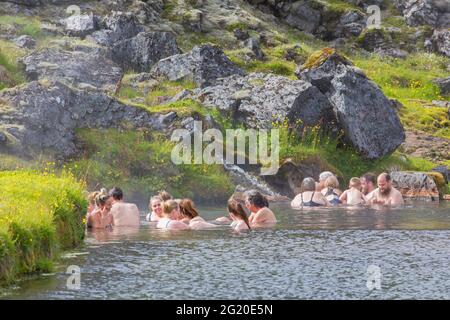 Touristes se baignant dans la source chaude à la vallée de Landmannalaugar, Réserve naturelle de Fjallabak, parc naturel près de Hekla / Hecla en été, Sudurland, Islande Banque D'Images