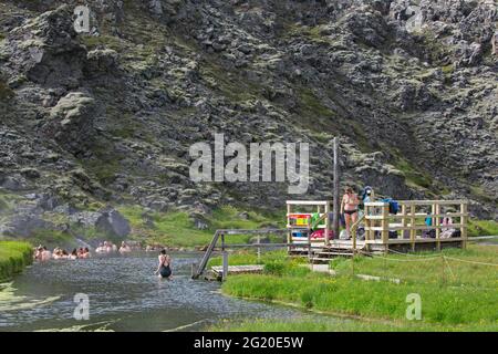 Touristes se baignant dans la source chaude à la vallée de Landmannalaugar, Réserve naturelle de Fjallabak, parc naturel près de Hekla / Hecla en été, Sudurland, Islande Banque D'Images