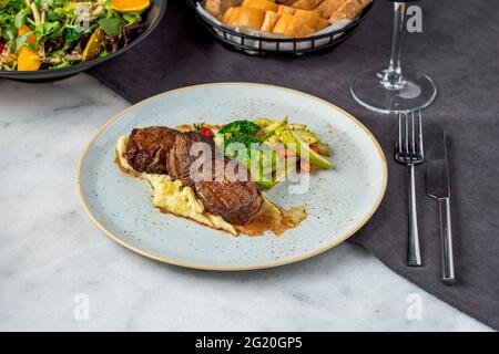 Filet de bœuf grillé sur une assiette en céramique avec beurre et thym. Recette de filet mignon avec légumes Banque D'Images