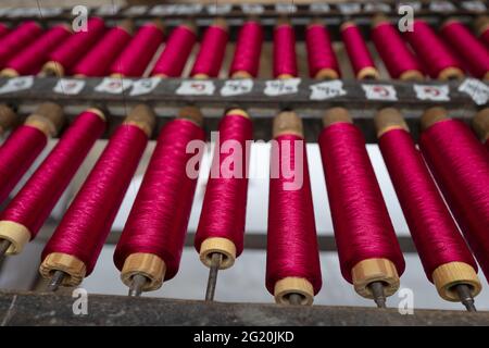 Atelier traditionnel de tisserands de Bevilacqua, les femmes travaillent sur des tisserres en bois vintage, produisant des textiles de luxe, à Venise depuis 1875 . Banque D'Images