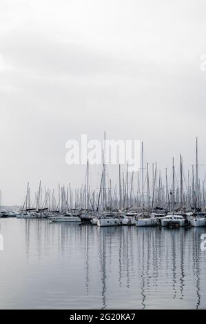 Magnifique paysage de la mer Égée à Athènes par temps nuageux. Silhouettes d'îles dans la brume. Voiles yachts près de la jetée. Banque D'Images