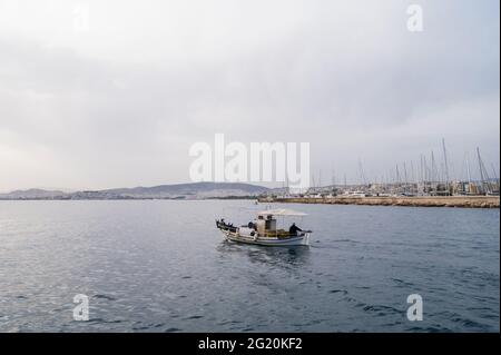 Magnifique paysage de la mer Égée à Athènes par temps nuageux. Bateau solitaire. Beaucoup de yachts à voile à la jetée. Montagnes en arrière-plan. Banque D'Images