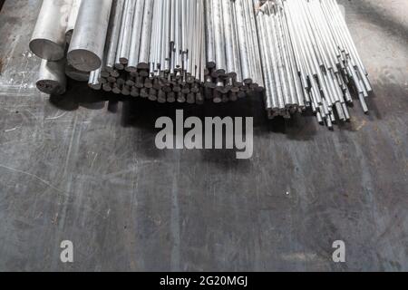 produits longs ronds en aluminium sur surface en acier noir Banque D'Images