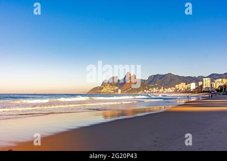 Lever du soleil sur la plage d'Ipanema à Rio de Janeiro avec la mer et les montagnes Banque D'Images