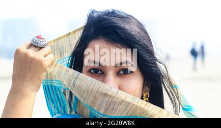 Jeune femme indienne portrait à sari avec son visage couvert. Belle femme musulmane indienne couvre son visage avec la saree. Banque D'Images