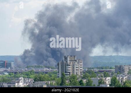 Feu dans la ville. La colonne noire de fumée s'élève au ciel au-dessus des bâtiments de la ville Banque D'Images