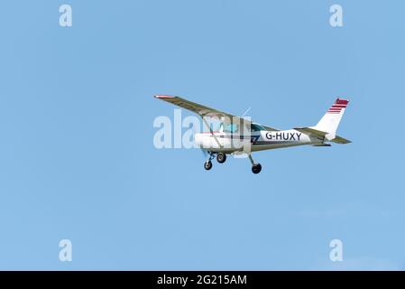 1979 Cessna 152 avion léger G-HUXY volant dans un ciel bleu clair au-dessus de l'aéroport Southend de Londres, Essex, Royaume-Uni. Grimpez dans une bonne visibilité dans un petit avion Banque D'Images