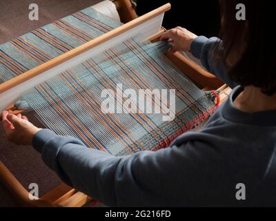 Handloom weaver fonctionne. Fabrication d'un tissu rayé à l'aide d'un métier à tisser Banque D'Images