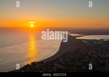 Fortuneswell, Portland, Dorset, Royaume-Uni. 7 juin 2021. Météo Royaume-Uni. Coucher de soleil vue depuis les hauteurs au-dessus de Fortuneswell à Portland à Dorset en regardant le long de Chesil Beach à la fin d'une chaude journée ensoleillée. Crédit photo : Graham Hunt/Alamy Live News Banque D'Images