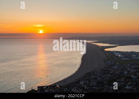 Fortuneswell, Portland, Dorset, Royaume-Uni. 7 juin 2021. Météo Royaume-Uni. Coucher de soleil vue depuis les hauteurs au-dessus de Fortuneswell à Portland à Dorset en regardant le long de Chesil Beach à la fin d'une chaude journée ensoleillée. Crédit photo : Graham Hunt/Alamy Live News Banque D'Images