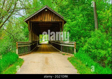 La passerelle en bois au-dessus de la zone marécageuse crée une promenade paisible et rafraîchissante à travers une région boisée pittoresque dans la campagne de l'ouest du Michigan. Banque D'Images