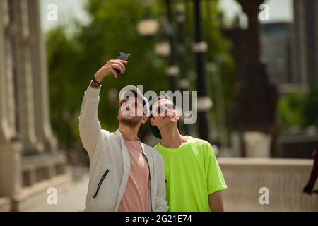 Deux amis mâles prennent des selfies avec les lunettes de soleil Banque D'Images