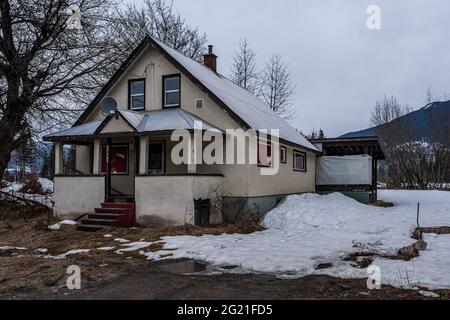 REVELSTOKE, CANADA - le 14 MARS 2021 : ancienne maison dans une petite ville, en soirée, au début du printemps avec de la neige Banque D'Images