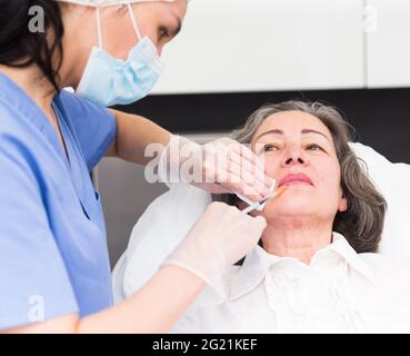 Cliente âgée pendant la procédure de mésothérapie faciale Banque D'Images