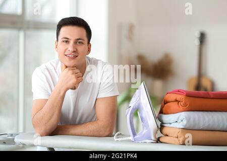 Beau jeune homme avec des vêtements repassés à la maison Banque D'Images