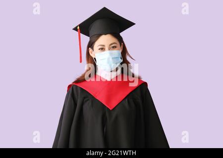 Une femme qui obtient son diplôme en masque de protection sur fond de couleur Banque D'Images