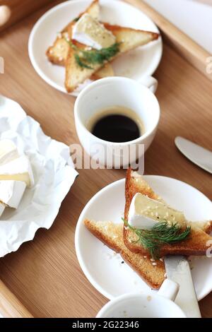 Petit-déjeuner de café expresso frais servi avec toasts et fromage Brie. Petit déjeuner maison, déjeuner. Banque D'Images