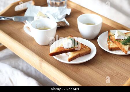 Petit déjeuner servi au lit. Café frais, toasts frits au fromage Brie sur plateau en bois. Détente à la maison. Banque D'Images