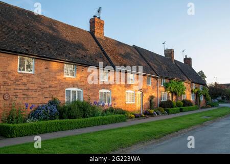 Lever de soleil sur une rangée de chalets dans le village de Cropredy, Oxfordshire, Angleterre Banque D'Images