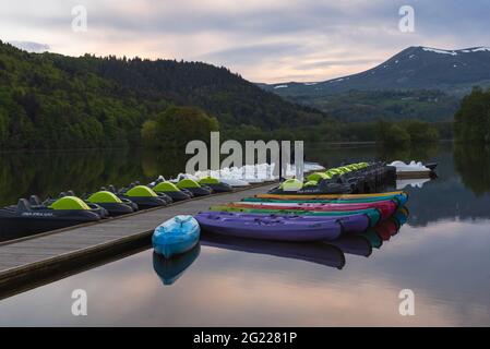 Lac Chambon, France - 28 mai 2021 : couple admirant la vue sur le lac Chambon au coucher du soleil. Parc naturel régional des Volcans d'Auvergne. Vacances romantiques Banque D'Images