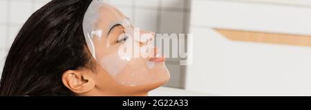 jeune femme afro-américaine avec masque en feuille sur le visage allongé dans le bain, bannière Banque D'Images