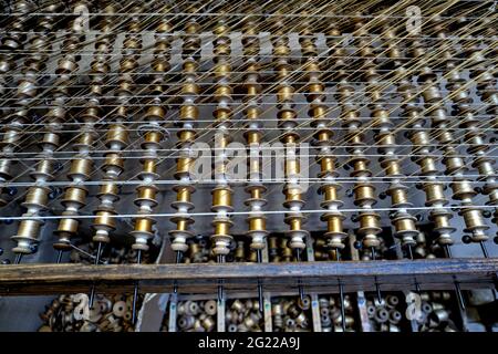 Le fil d'or fuzes sur une métiers en bois traditionnels des tisserands de Bevilacqua, produisent du textile de luxe à Venise depuis 1875. Banque D'Images