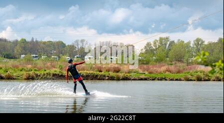 Homme sur le ski nautique du côté, tiré par un ascenseur Banque D'Images