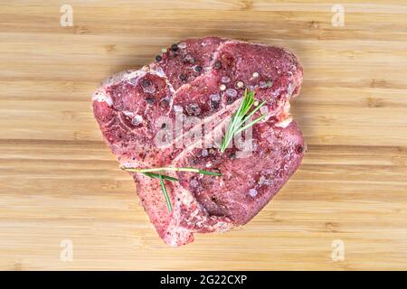 Black angus t os steak isolé de viande crue os. Beefsteak de veau coupé pour barbecue. Longe de viande bovine vieillie non cuite, assaisonnement au sel et au romarin, marina Banque D'Images