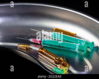 Gros plan de deux seringues et ampoules brisées dans un bassin de rein Banque D'Images