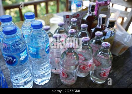 Rangées d'eau, soda et whisky sur table en bois Banque D'Images