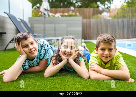 Portrait de trois enfants allongé sur une herbe Banque D'Images