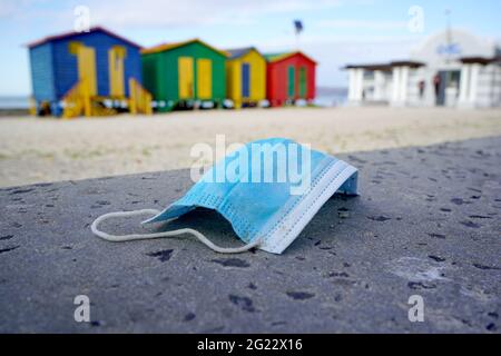 Vieux masque médical utilisé polluant la plage Banque D'Images