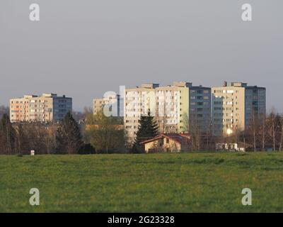 Champ herbacé et blocs d'appartements à la ville européenne de Bielsko-Biala dans le quartier de Silésie en Pologne, ciel bleu clair en 2020 chaude et ensoleillé jour de printemps le mois d'avril. Banque D'Images