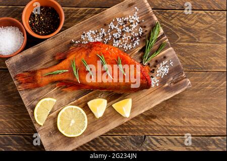 Délicieux poisson fumé perch océan sur planche à découper en bois pour une alimentation saine, un régime ou un concept de cuisine, sélectif foyer. Banque D'Images