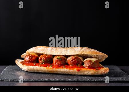 Sous-sandwich au ballon de viande sur fond d'ardoise noire Banque D'Images