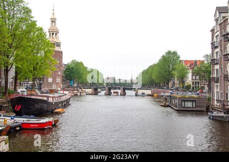 AMSTERDAM, PAYS-BAS. 06 JUIN 2021. Belle vue sur Amsterdam avec des maisons hollandaises typiques, des ponts et chanel. Petits bateaux sur le remblai Banque D'Images